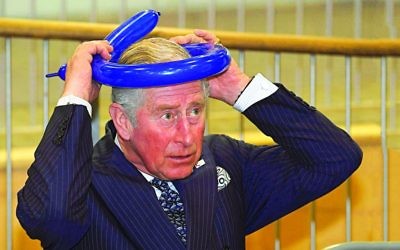 Prince Charles fashioning a balloon crown during his visit to the school