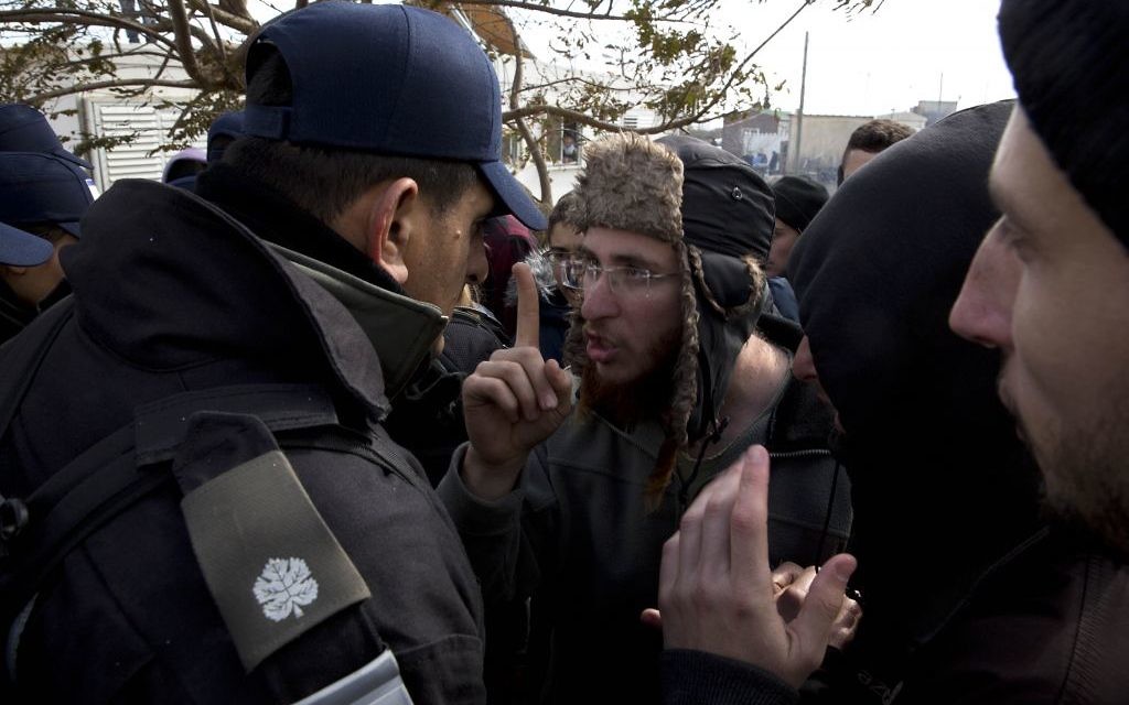 Settlers stand in front of a home in the West Bank outpost of Amona  (AP Photo/Oded Balilty)