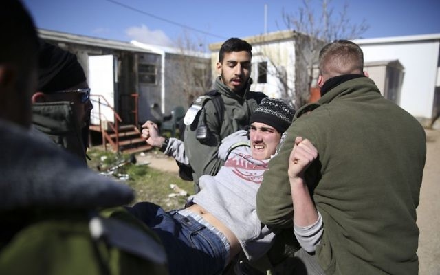 Israeli police detain settlers in the West Bank outpost of Amona.
