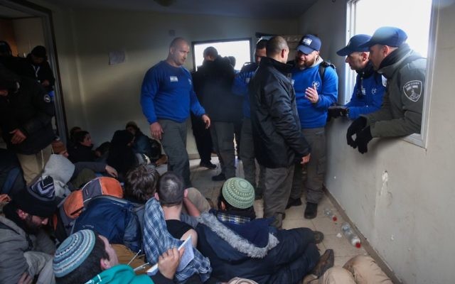 Israeli police evict settlers from the West Bank outpost of Amona, Wednesday. (Photo by: JINIPIX)