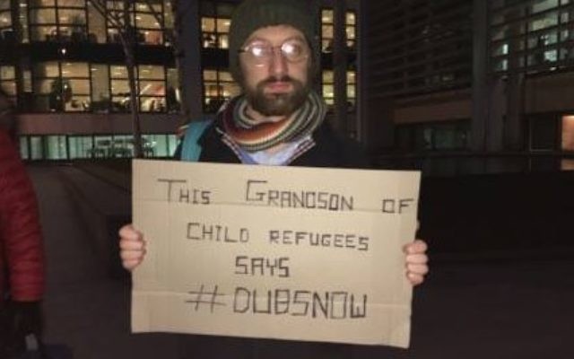 A descendent of a refuge holds a placard urging the government to allow in more children