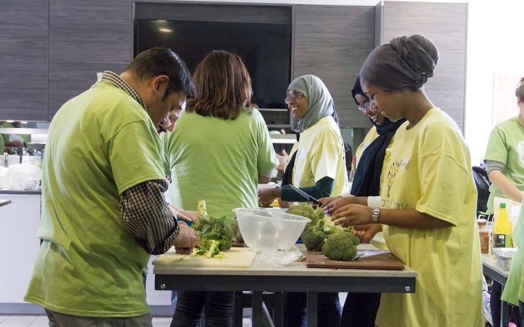 Jewish and Muslim volunteers cooking a three course meal for the homeless together, on Sadaqa Day Jewish and Muslim volunteers cooking a three course meal for the homeless together, on Sadaqa Day