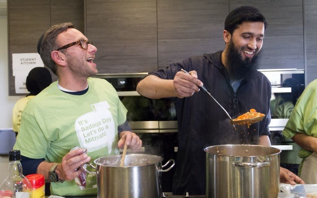 Jewish and Muslim volunteers cooking a three course meal for the homeless together, on Sadaqa Day Jewish and Muslim volunteers cooking a three course meal for the homeless together, on Sadaqa Day