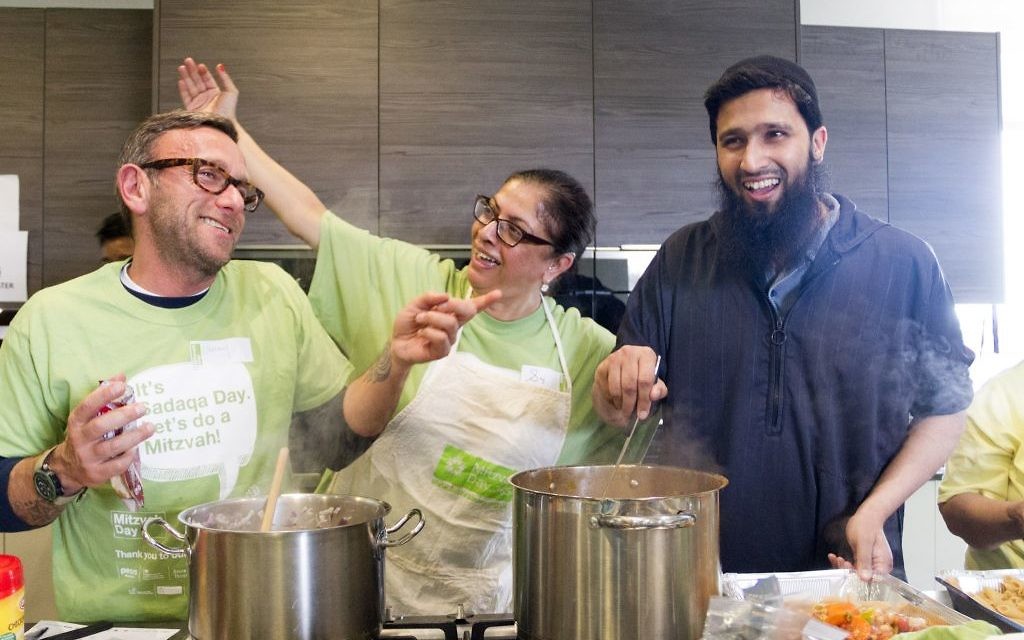 Jewish and Muslim volunteers cooking a three course meal for the homeless together, on Sadaqa Day Jewish and Muslim volunteers cooking a three course meal for the homeless together, on Sadaqa Day