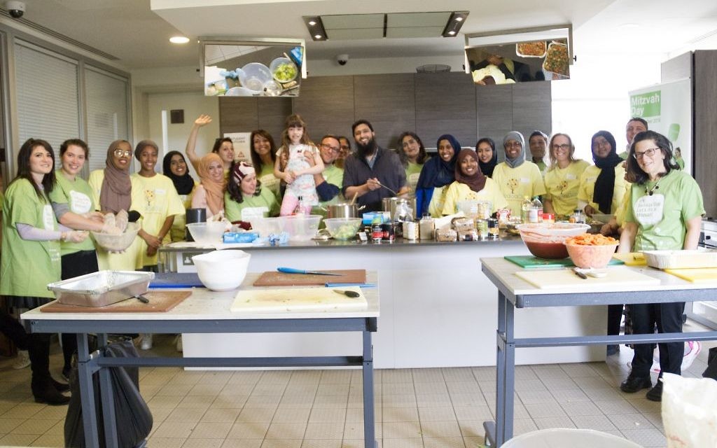 Jewish and Muslim volunteers pose together after cooking a three course meal for the homeless together, on Sadaqa Day Jewish and Muslim volunteers pose together after cooking a three course meal for the homeless together, on Sadaqa Day