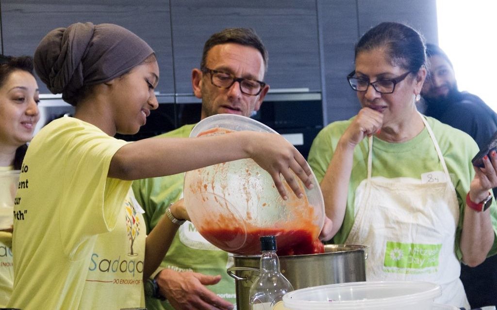 Jewish and Muslim volunteers cooking a three course meal for the homeless together, on Sadaqa Day Jewish and Muslim volunteers cooking a three course meal for the homeless together, on Sadaqa Day