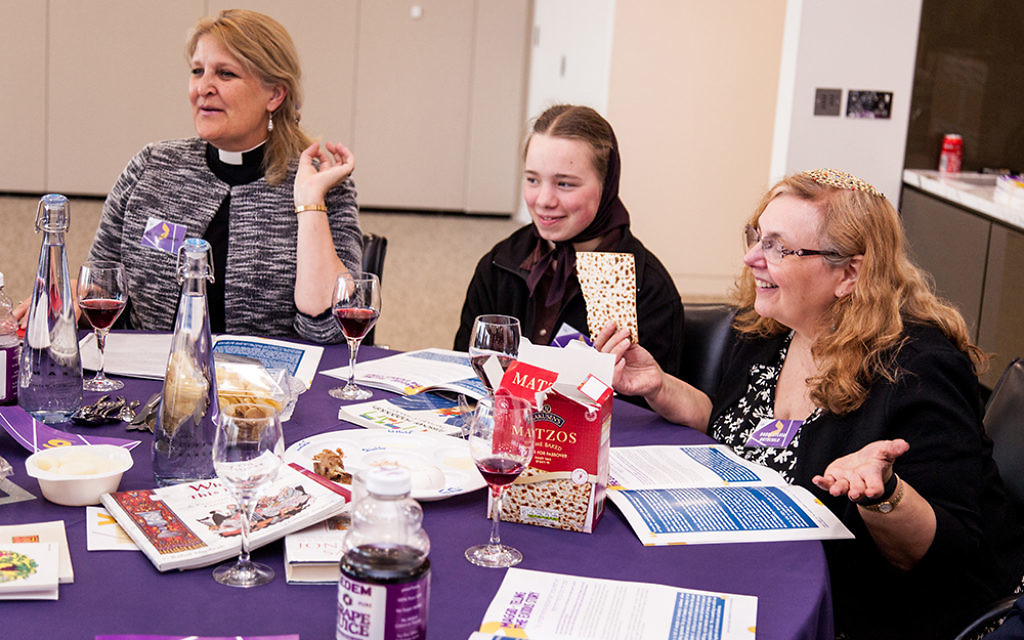Christian and Jewish guests opening their box of matzah at the seder