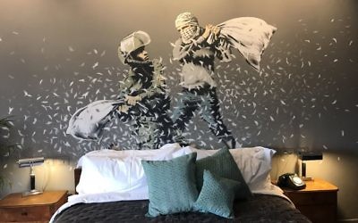 An Israeli solider and Palestinian man have a pillow fight in one of the Banksy artworks on the walls of a hotel he has created in the Palestinian territories. [Picture: Channel 4] (March 2017)