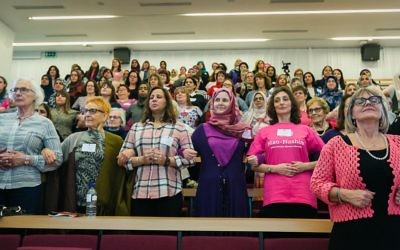Jewish and Muslim women link arms at the inaugural Nisa-Nashim conference. 

(Picture credit: Yakir Zur)