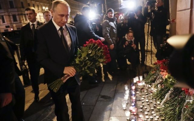 Russian President Vladimir Putin, left, lays flowers at a place near the Tekhnologichesky Institut subway station in St.Petersburg, Russi 

(AP Photo/Dmitri Lovetsky)
