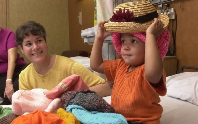 Twenty-two-month-old Naudia Turner, who had a Wilms tumor surgically removed, tried on nearly 20 hats before settling on two of her favorites. When Mad Hatters Kathy Flickinger (left) and Marion Krulas showed up, their hats offered a fun diversion to one of NaudiaÕs biweekly trips to the hospital for chemotherapy treatments.  http://www.af.mil/news/airman/0602/hatters.html
(U.S. Air Force photo/Master Sgt. Lance Cheung)