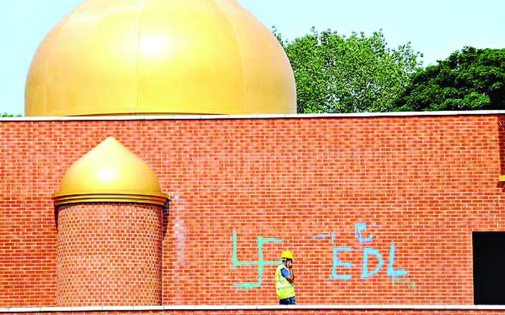 Hateful graffiti, including a swastika, daubed onto the wall o a mosque