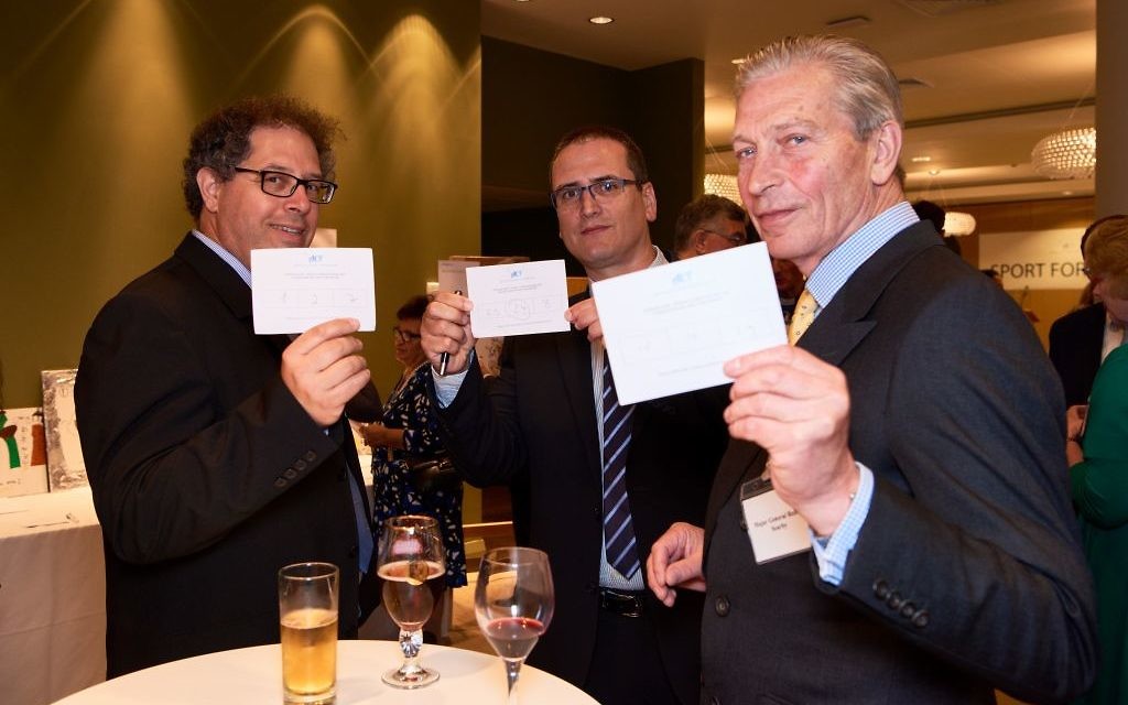Itay Brafman, Zvi Derin and General Searby with their voting slips for the art exhibition