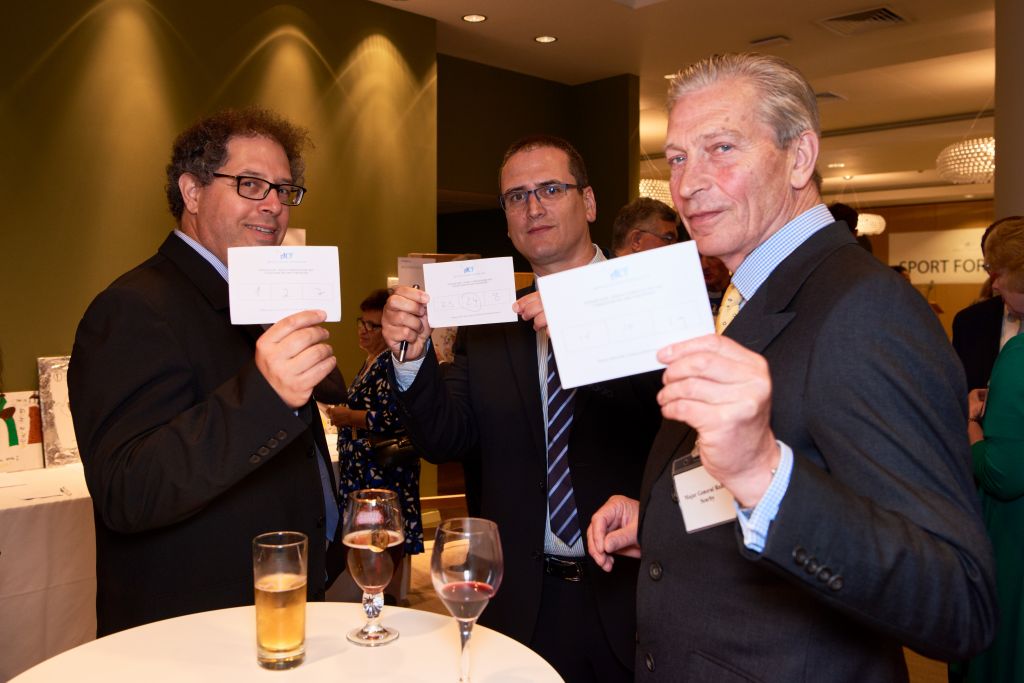 Itay Brafman, Zvi Derin and General Searby with their voting slips for the art exhibition