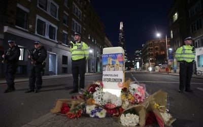 Police officers on duty next to floral tributes left on Southwark Street, London, near the scene of last night's terrorist incident.

Photo credit: Yui Mok/PA Wire