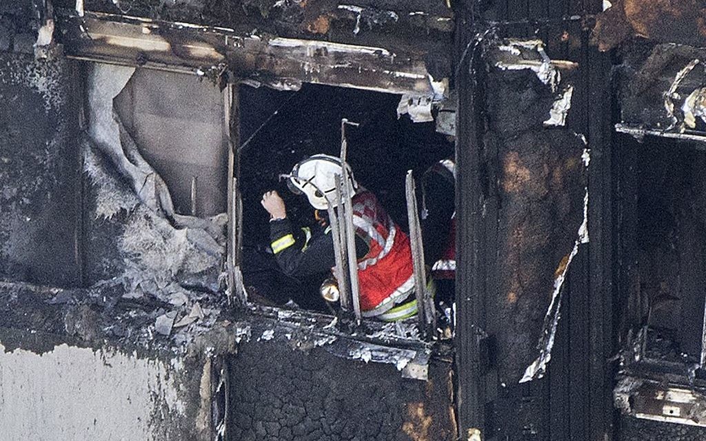 A firefighter investigates a floor after a fire engulfed the 24-storey Grenfell Tower in west London. 

 Photo credit: Rick Findler/PA Wire