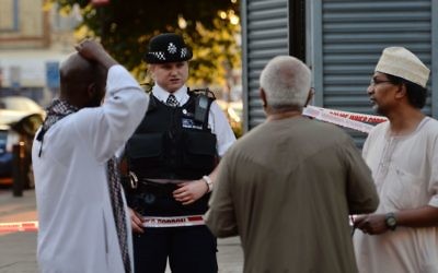 A police officer talks to local people at Finsbury Park in north London, where one man has died, eight people taken to hospital and a person arrested after a van struck pedestrians.

 Photo credit: Victoria Jones/PA Wire