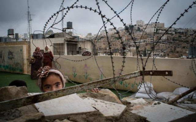 A little girl in Hebron looks out from her playground behind razor wire

Photo credit: Bath Abbey's website: http://www.bathabbey.org/whats-on/events/raising-voices-photographic-exhibition