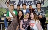 One direction fans pose with the figures at Madame Tussauds