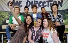 One direction fans pose with the figures at Madame Tussauds