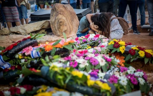 Friends and relatives mourn at the graves of Yosef Salomon (70), his daughter Haya (46) and son Elad (35), after their funeral, attended by thousands, at the Modiin Cemetery, in July, 2017. 


Photo by: JINIPIX