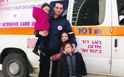Nathan Levy with his MDA ambulance and three
of his four children.