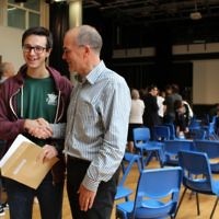 JCoSS headteacher shakes hands with a top performing student during August's A-Level results
