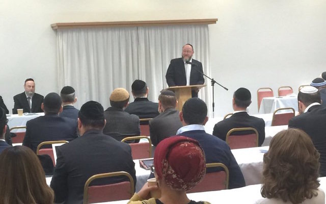 Chief Rabbi Ephraim Mirvis speaking in front of 100 Orthodox rabbis
