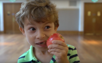 A boy bites into an apple during WLS's Rosh Hashanah video