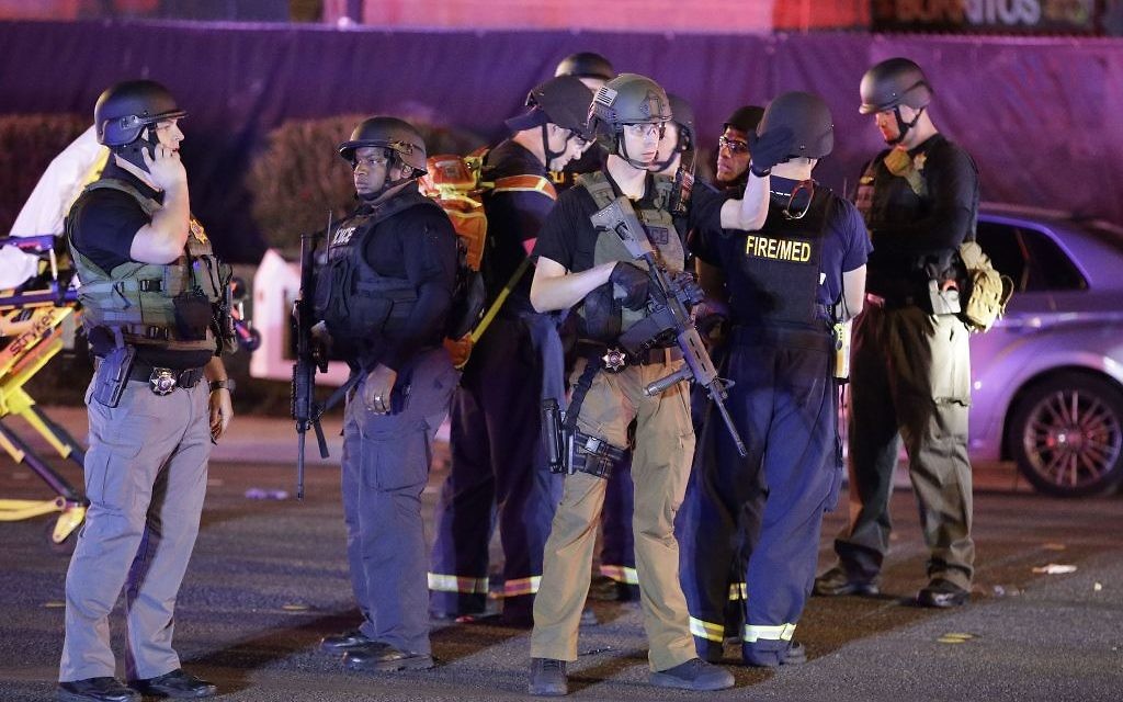 Police officers stand at the scene of the mass shooting near the Mandalay Bay resort and casino on the Las Vegas Strip,

(AP Photo/John Locher)