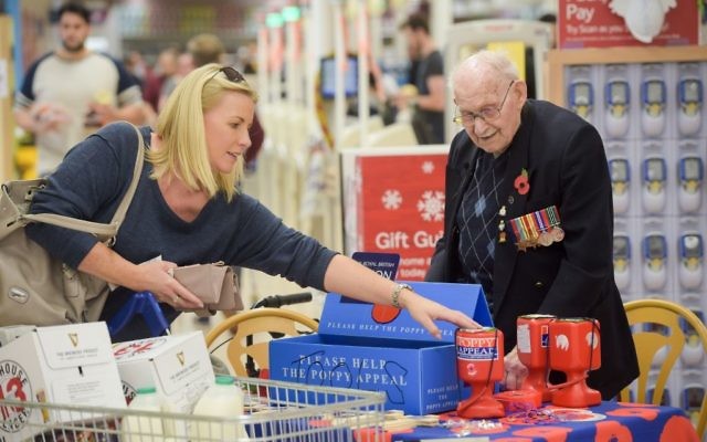 Poppy seller Ron Jones, who is 100 years old, at his selling station inside Tesco supermarket, Newport. 

Photo credit: Ben Birchall/PA Wire