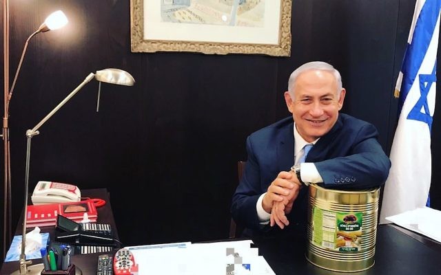 Prime Minister Benjamin Netanyahu posing with a large can of pickles, Oct. 23, 2017. (Courtesy of Prime Minister’s Office) Via JTA