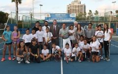 Sir Cliff (centre) plays a tennis racket like it's a guitar, surrounded by Jewish and Arab kids Sir Cliff (centre) plays a tennis racket like it's a guitar, surrounded by Jewish and Arab kids