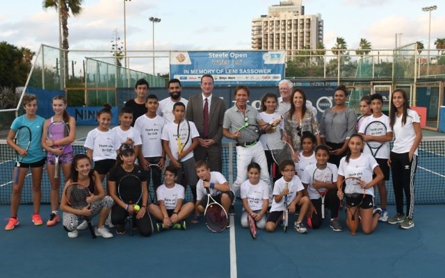 Sir Cliff (centre) plays a tennis racket like it's a guitar, surrounded by Jewish and Arab kids