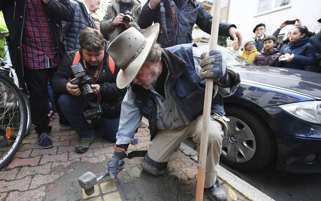 Artist Gunter Demnig lays four "Stolpersteine" (stumbling blocks) for Karolina Cohn and her family in Frankfurt, Germany, Monday, Nov. 13, 2017. Relatives participated in a memorial ceremony for Karolina Cohn, a Jewish girl from Frankfurt who perished in the Holocaust more than 70 years ago. The story of her life and death had been all but erased by the Nazis, until archeologists last year unearthed a silver pendant engraved with her birth date and birthplace at the grounds of the former Sobibor death camp. (Arne Dedert/dpa via AP) Artist Gunter Demnig lays four "Stolpersteine" (stumbling blocks) for Karolina Cohn and her family in Frankfurt, Germany, Monday, Nov. 13, 2017. Relatives participated in a memorial ceremony for Karolina Cohn, a Jewish girl from Frankfurt who perished in the Holocaust more than 70 years ago. The story of her life and death had been all but erased by the Nazis, until archeologists last year unearthed a silver pendant engraved with her birth date and birthplace at the grounds of the former Sobibor death camp. (Arne Dedert/dpa via AP)