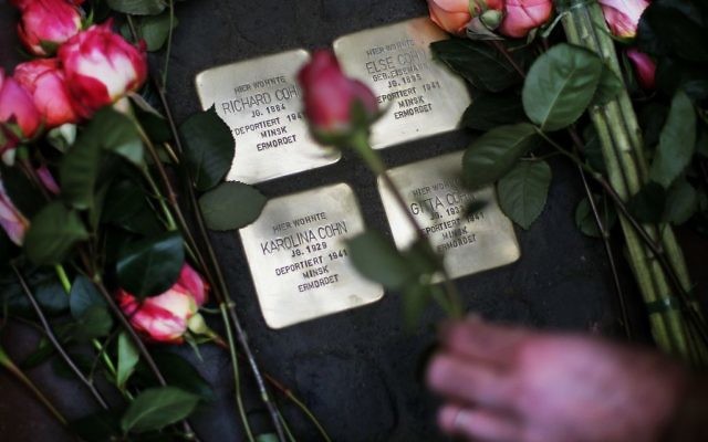 Roses are laid on four "Stolpersteine" (stumbling blocks) for Karolina Cohn and her family in Frankfurt, Germany

 (AP Photo/Michael Probst)