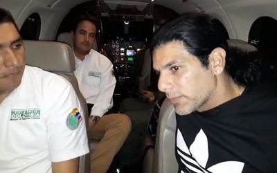 Screen capture from video showing alleged crime lord Assi Ben Mosh, right, on a flight after being expelled from Columbia. (YouTube via The Times of Israel )