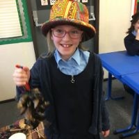 A student at  Keser Torah in Gateshead holding  goats’ hooves, used as an instrument