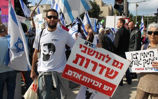 Im Tirtzu activist holding a sign reading "The residents of Sderot also have Human Rights"