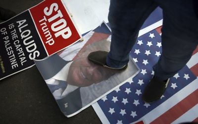 A Palestinian steps on a poster of U.S. President Donald Trump and a representation of the American flag during a protest against the U.S. decision to recognise Jerusalem as Israel's capital, in Gaza City T  (AP Photo/ Khalil Hamra)