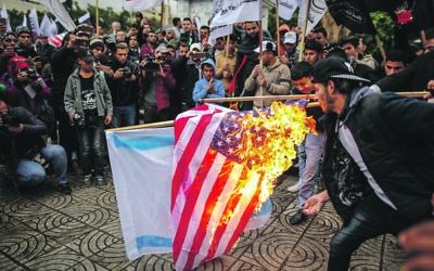 American and Israeli flags are burned by protesters
