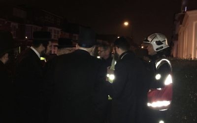 Members of the Charedi community speak with firefighters following the fire on the last night of Chanukah