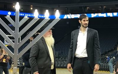 Omir Casspi lit the menorah on court, having helped the Golden State Warriors to victory over the Dallas Mavericks