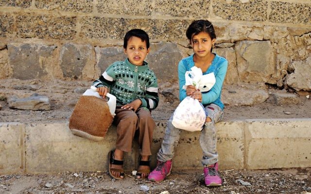 Children [not related to this article] affected by the ongoing crisis wait to receive food from a charity food distributing centre in Sana’a, Yemen
