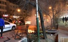 An overturned bin is set alight in a Tehran street, as demonstrations across the Islamic Republic spread during the new year period.