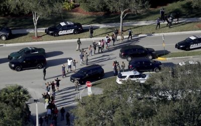 Students hold their hands in the air as they are evacuated by police from Marjory Stoneman Douglas High School in Parkland, Fla , after a shooter opened fire on the campus. 

(Mike Stocker/South Florida Sun-Sentinel via AP)
