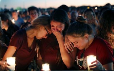 Students console each other as they weep during a candlelight vigil for the victims of the Wednesday shooting at Marjory Stoneman Douglas High School, in Parkland, Fla., 

(AP Photo/Gerald Herbert)