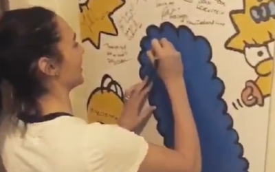Gal Gadot signing a Simpsons poster

Source: Screenshot from video posted on Twitter