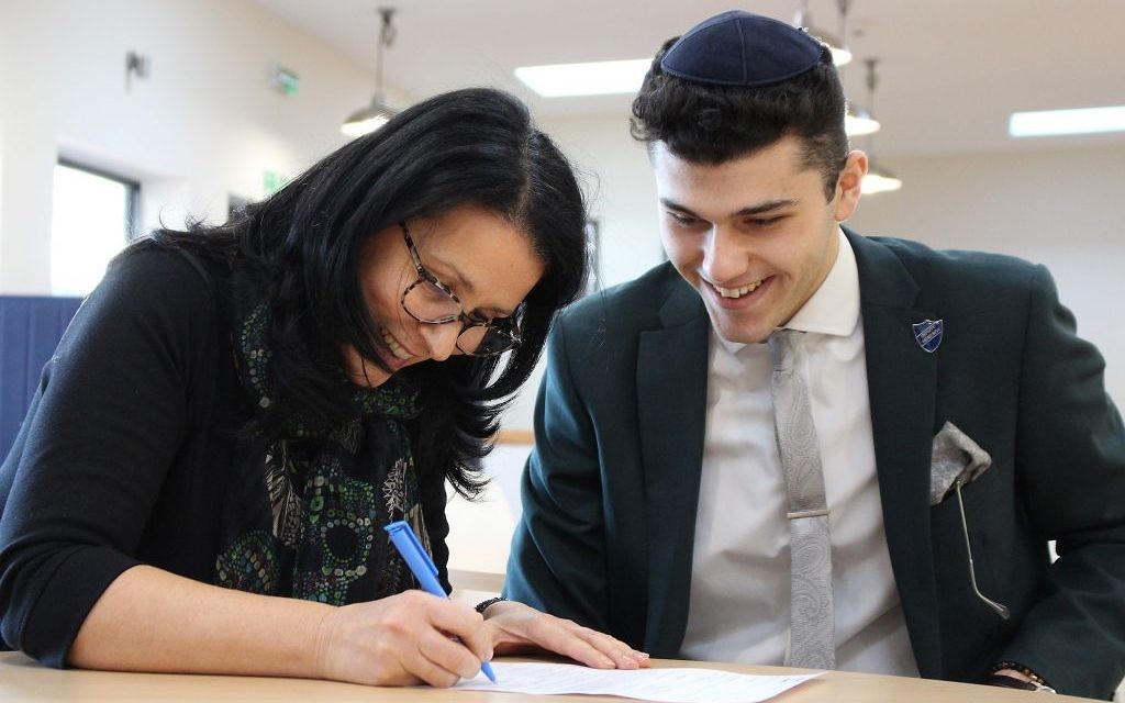 Reuben signing on the dotted line, with his mum