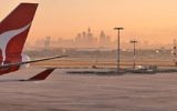 The view of Sydney at dawn from the airport, with a Qantas plane